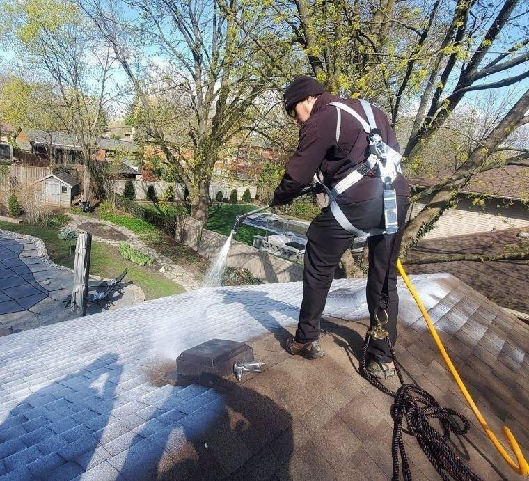 Technician applying Reactiv8 roof rejuvenation treatment on asphalt shingles