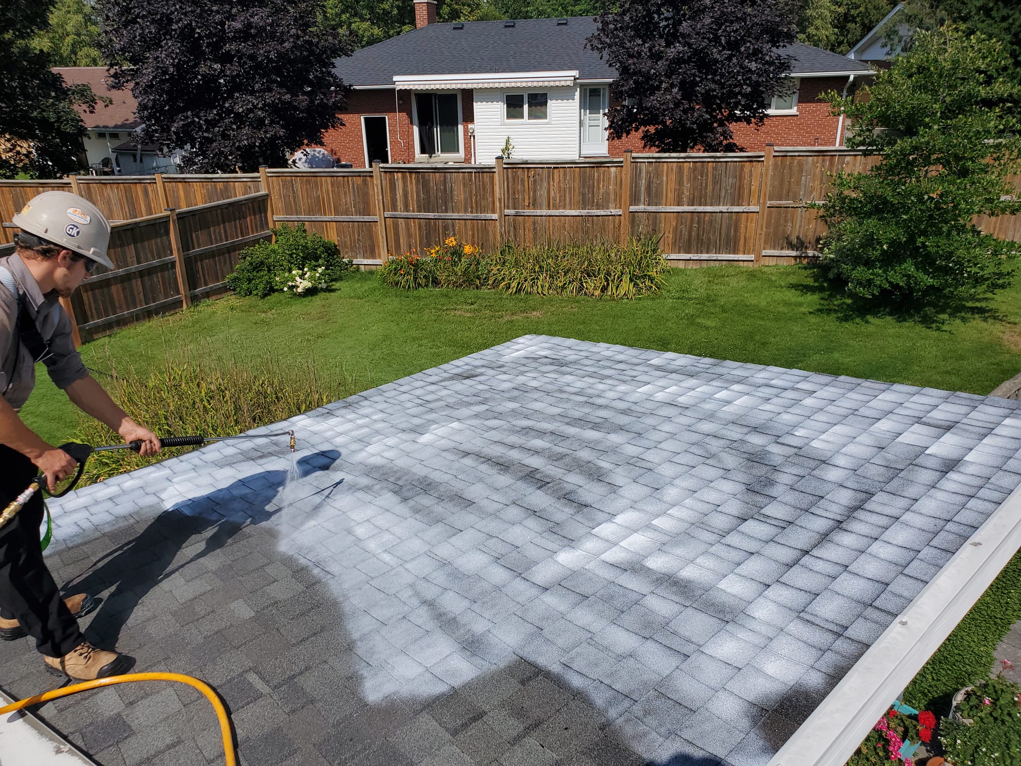 Roofing crew using Reactiv8 application equipment during roof rejuvenation project.
